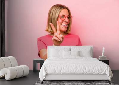 young caucasian woman isolated on pink background showing number two with fingers. Wall mural