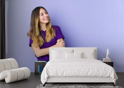 Young caucasian woman isolated on purple background smiling confident with crossed arms. Wall mural