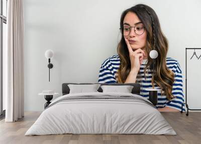 Young caucasian woman isolated on white background looking sideways with doubtful and skeptical expression. Wall mural