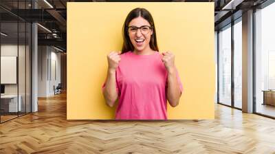 Young caucasian woman isolated on yellow background cheering carefree and excited. Victory concept. Wall mural