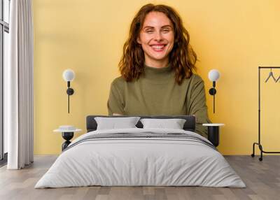 Young caucasian woman isolated on yellow background who feels confident, crossing arms with determination. Wall mural