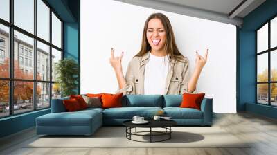 Young caucasian woman  isolated showing rock gesture with fingers Wall mural