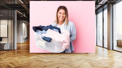 Young caucasian woman picking up a dirty clothes laughing and having fun. Wall mural