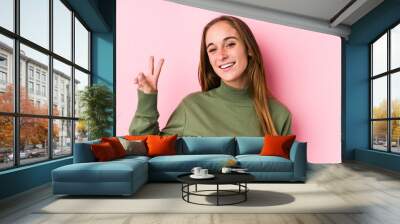 Young caucasian woman posing isolated  showing victory sign and smiling broadly. Wall mural