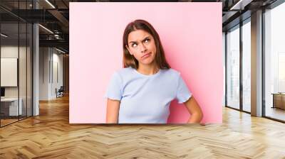 Young caucasian woman wearing a ski clothes isolated confused, feels doubtful and unsure. Wall mural