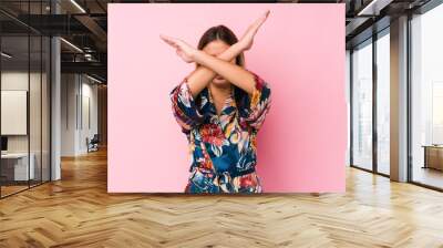 Young caucasian woman wearing pajamas keeping two arms crossed, denial concept. Wall mural