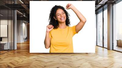 Young cute brazilian woman isolated celebrating a special day, jumps and raise arms with energy. Wall mural