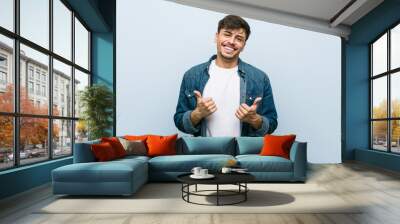 Young hispanic cool man raising both thumbs up, smiling and confident. Wall mural