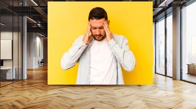 Young hispanic man isolated on yellow background having a head ache, touching front of the face. Wall mural