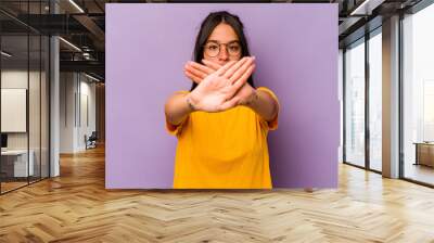 Young hispanic woman isolated on purple background doing a denial gesture Wall mural