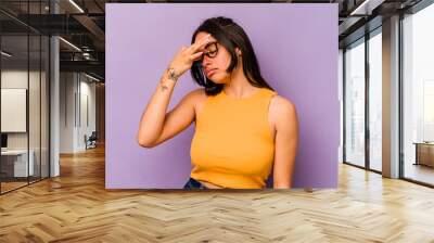 Young hispanic woman isolated on purple background having a head ache, touching front of the face. Wall mural