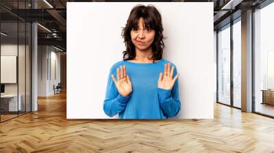 Young hispanic woman isolated on white background rejecting someone showing a gesture of disgust. Wall mural