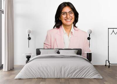 Young Indian business woman wearing a pink suit isolated happy, smiling and cheerful. Wall mural