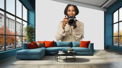 Young Indian photographer woman holding a professional camera isolated Wall mural