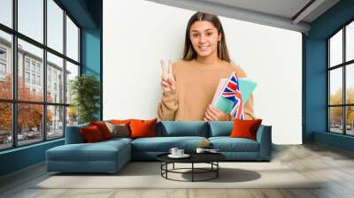 Young Indian woman holding an United Kingdom flag isolated on white background showing number two with fingers. Wall mural