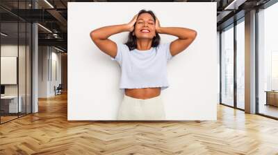 Young Indian woman isolated on white background laughs joyfully keeping hands on head. Happiness concept. Wall mural