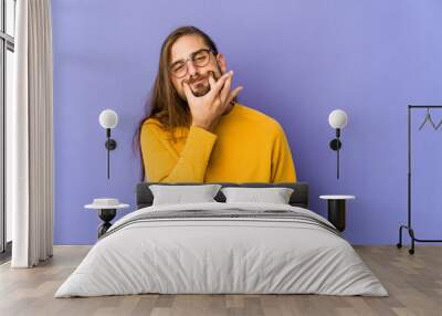 Young man with long hair look doubting between two options. Wall mural