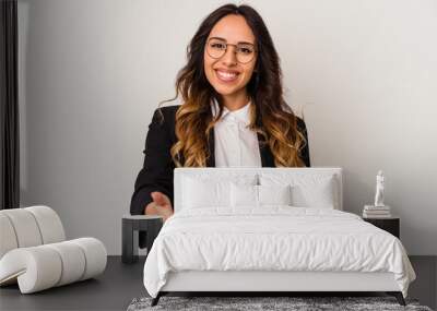 Young mexican business woman isolated on white background stretching hand at camera in greeting gesture. Wall mural