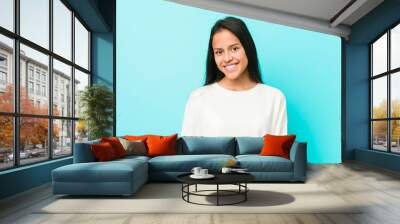 Young pretty hispanic woman happy, smiling and cheerful. Wall mural