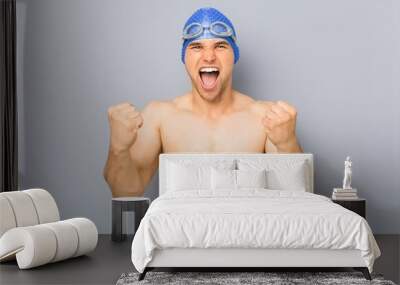 Young professional swimmer man cheering carefree and excited. Victory concept. Wall mural