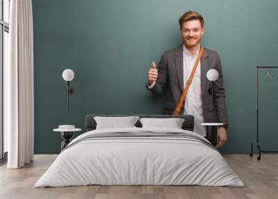 Young redhead business man smiling and raising thumb up Wall mural