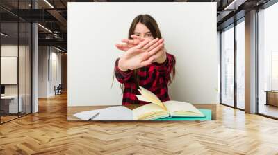 Young teenager going back to her routine doing homeworks doing a denial gesture Wall mural