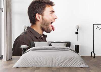 young man showing his tongue on a white background Wall mural