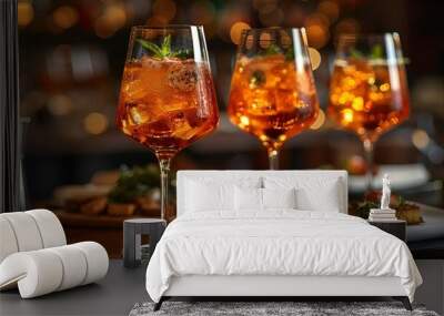 Three glasses of chilled wine adorned with ice and garnishes. Wall mural