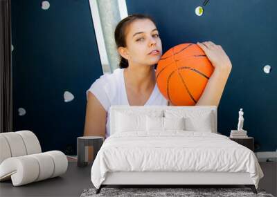 Portrait of a beautiful and tought female basket player Wall mural