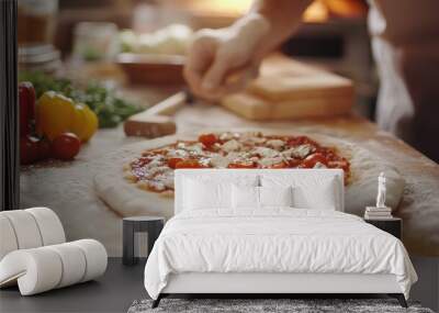 Close-up of a pizza with tomato sauce, cheese and cherry tomatoes being prepared in a kitchen. Wall mural