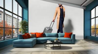 Elegant young handsome man with luggage. Studio fashion portrait. Wall mural