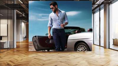 handsome man near the car. luxury life. Wall mural