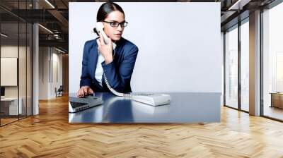 Portrait of a business woman working at her desk Wall mural