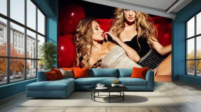 Two sexy girls on lounge. Celebrating. Wall mural