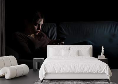 Depressed woman lying on bed using smartphone at late night, exhausted woman scrolling through social networks suffer from sleep disorder Wall mural