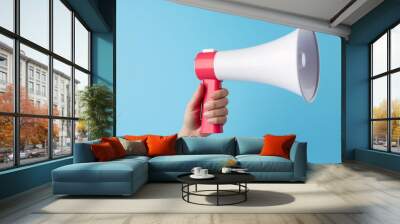 hand holding a red and white megaphone against a blue background, communication and announcement con Wall mural