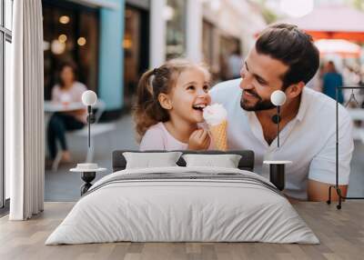 Happy daughter sitting with dad on the city street and eating ice cream outdoor. Cheerful little girl having fun spending time with father, good relationship between dad and daughter Wall mural