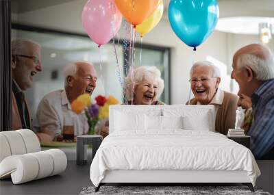 Happy group of senior people smiling and celebrating a birthday party with balloons and cake at a retirement home. Elderly people lifestyle Wall mural