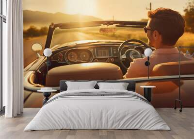 Happy young couple driving into the sunset on a country road in a classic vintage sports car. Wall mural