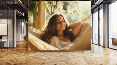 Relaxed young woman resting in comfortable hammock at home Wall mural