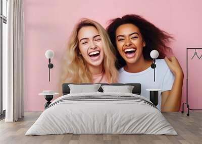 Two cheerful interracial best friends laughing and having a good time together isolated on pink studio background. Positive emotions and feelings concept Wall mural