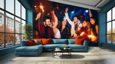 Group of friends having fun and holding sparklers at New Year's party Wall mural