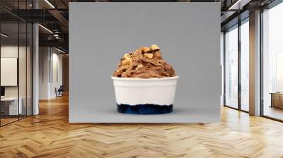 Hazelnut ice cream in cup on gray background Wall mural