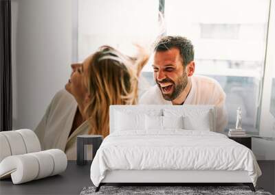 Young couple in love having fun with hair dryer in the bathroom Wall mural