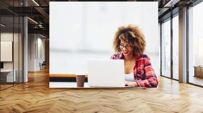 Young woman working on laptop
 Wall mural