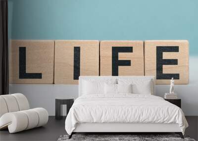 LIFE - word concept from wooden blocks on blue background Wall mural