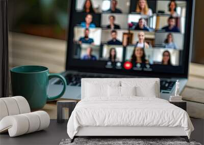 A blue mug sits in front of a laptop with a video conference on the screen. Wall mural