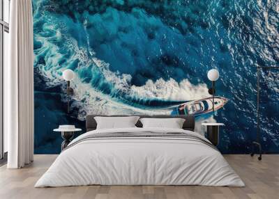 A white luxury cruise ship yacht powerboat moves in the middle of the blue sea with splashes of white foam on its tail visible from above Wall mural