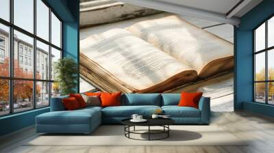 close up of blank antique book sheet on wooden table with large page visible light and shadow from daylight from window Wall mural