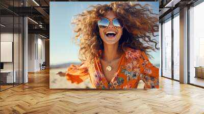 Happy smiling woman on beach with wavy hair wearing dark orange aquamarine floral patterned shirt and stylish sunglasses with dynamic optimistic attitude Wall mural